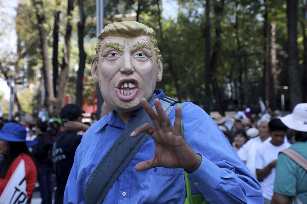 A protester in Mexico City wearing a Trump mask. Photo Credit: Rex Features