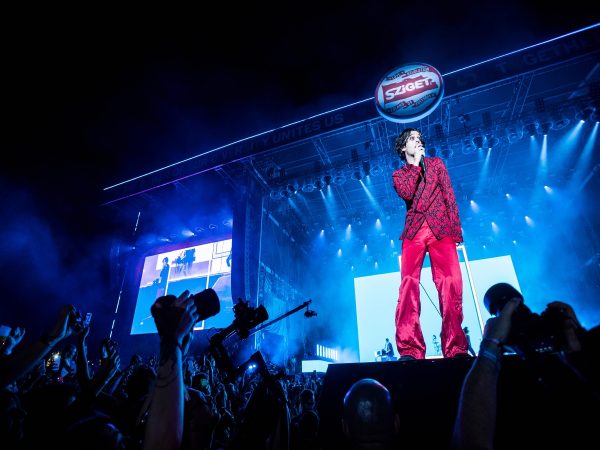 Matty Healy from The 1975 wearing an all-red suit during his performance in Budapest