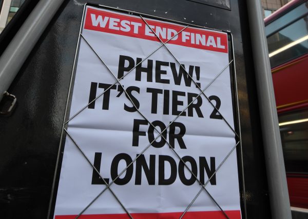 A headline on a wall in London that says 'PHEW! IT'S TIER 2 FOR LONDON'. 