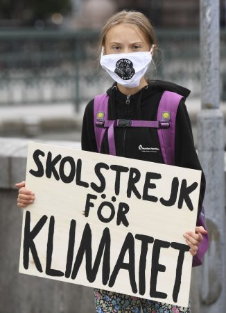 Greta Thunberg holding a sign which reads: School strike for climate.