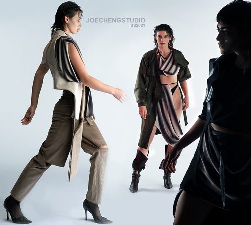 Three models wearing Joe Cheng's graduate collection. One is walking, one is staring into the camera, and the final one is standing in the shadow. The clothes are loose-fitted and have a neutral colour palette.