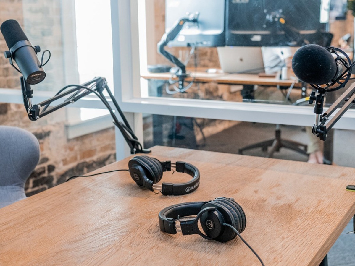 Podcast mics and headphones on a table.