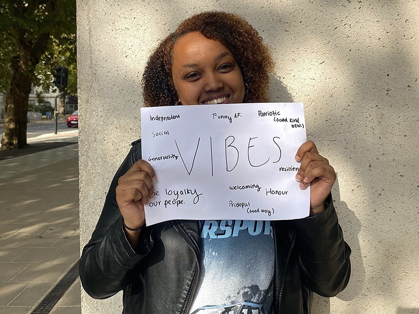 Student holding up a sign saying vibes.