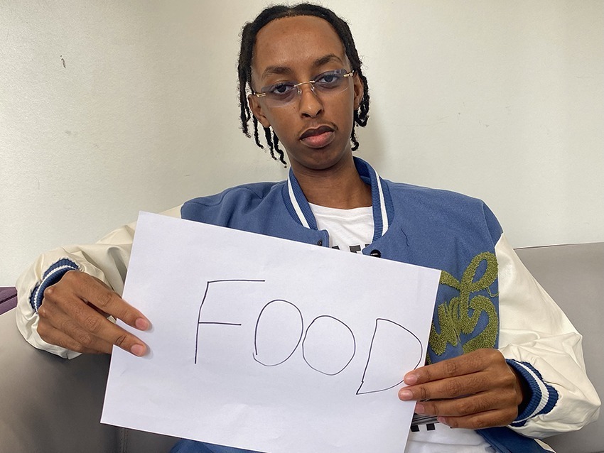 Student holding up a sign saying food.