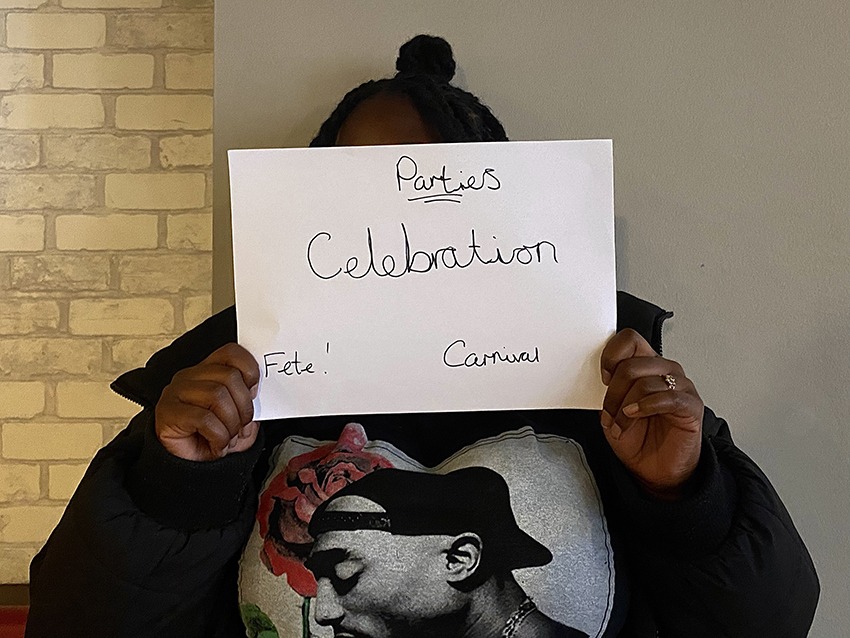 Student holding up a sign saying parties, celebration and carnival.