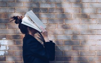 Stressed person holding a book to her face