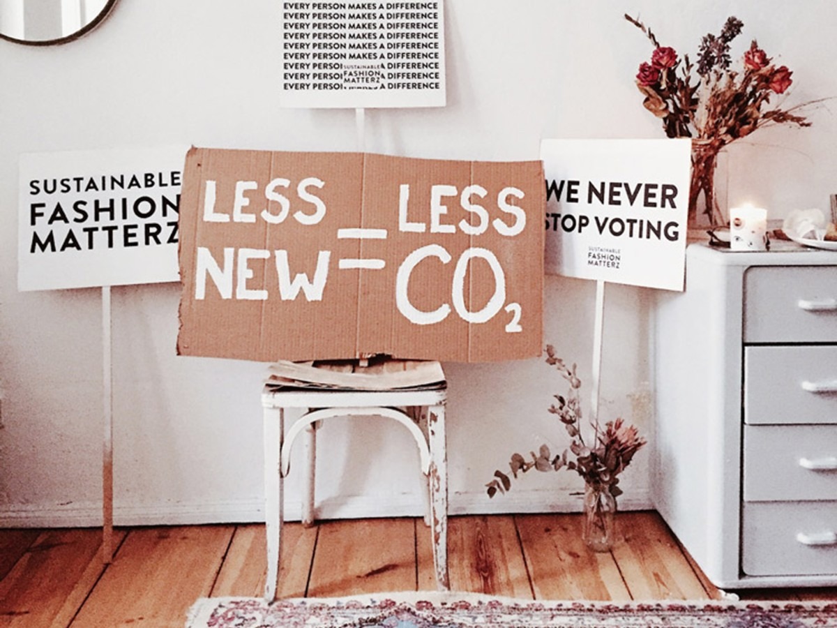 Placards saying less new, less CO2 by a chair