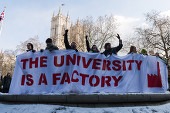 Protestors holding a sign saying 'the university is a factory'