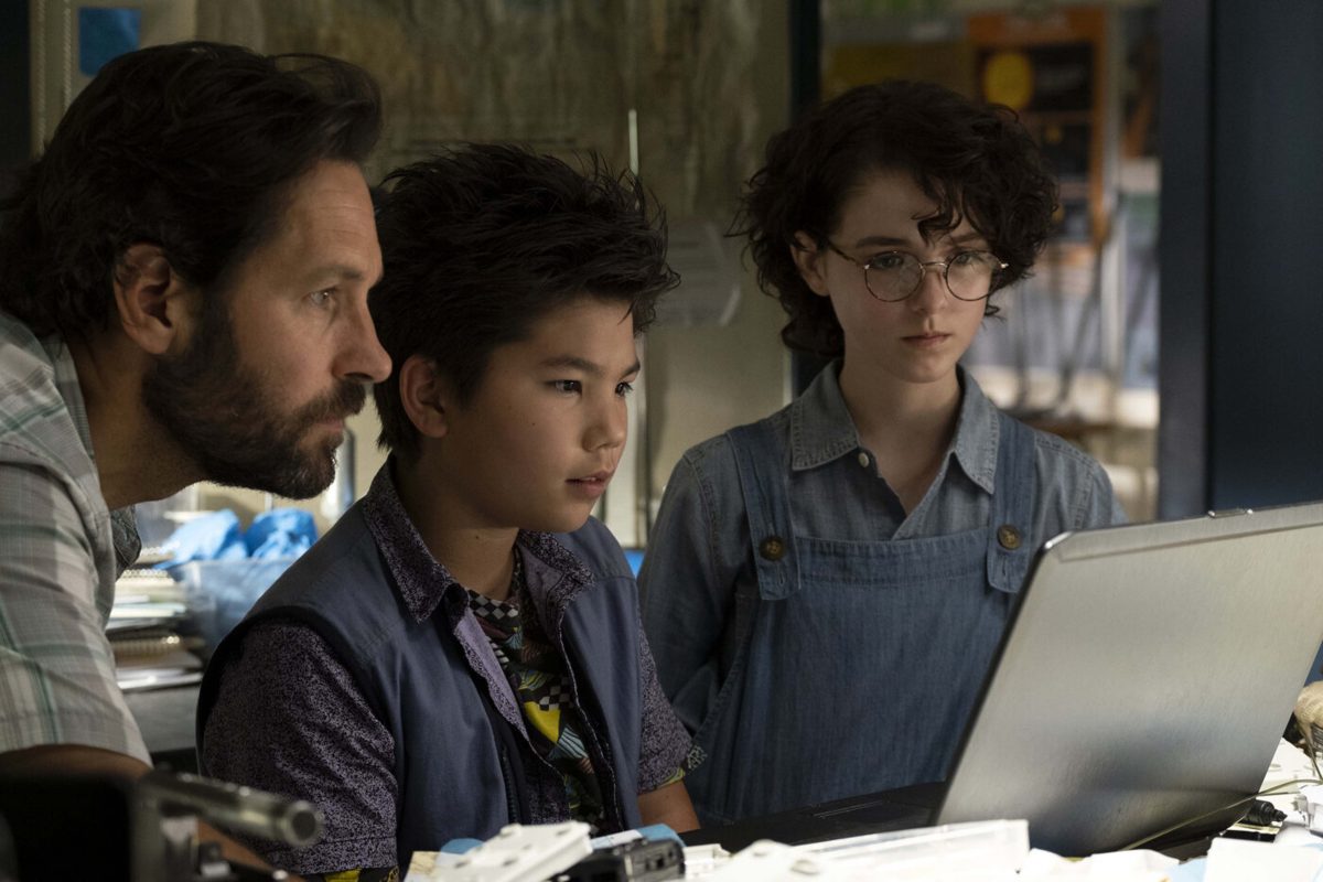 Paul Rudd (left), Logan Kim (middle), Mckenna Grace (right) looking at computer screen in a scene from the movie