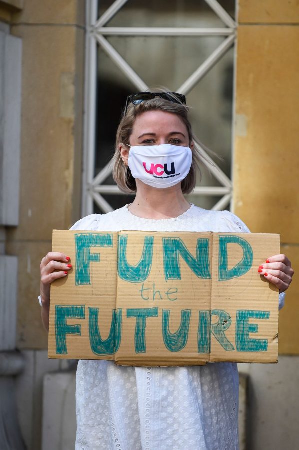 A UCU protester holding a sign "fund the future"