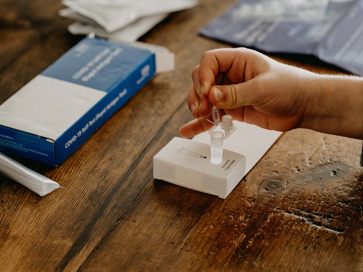 A hand is using a lateral flow test kit.