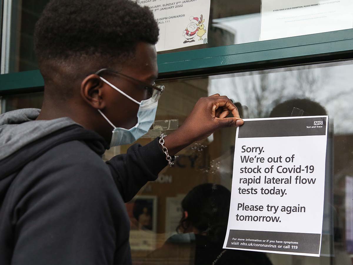 A staff member displays a sign in the window of a north London pharmacy, which has run out of NHS Lateral Flow Test kits again.