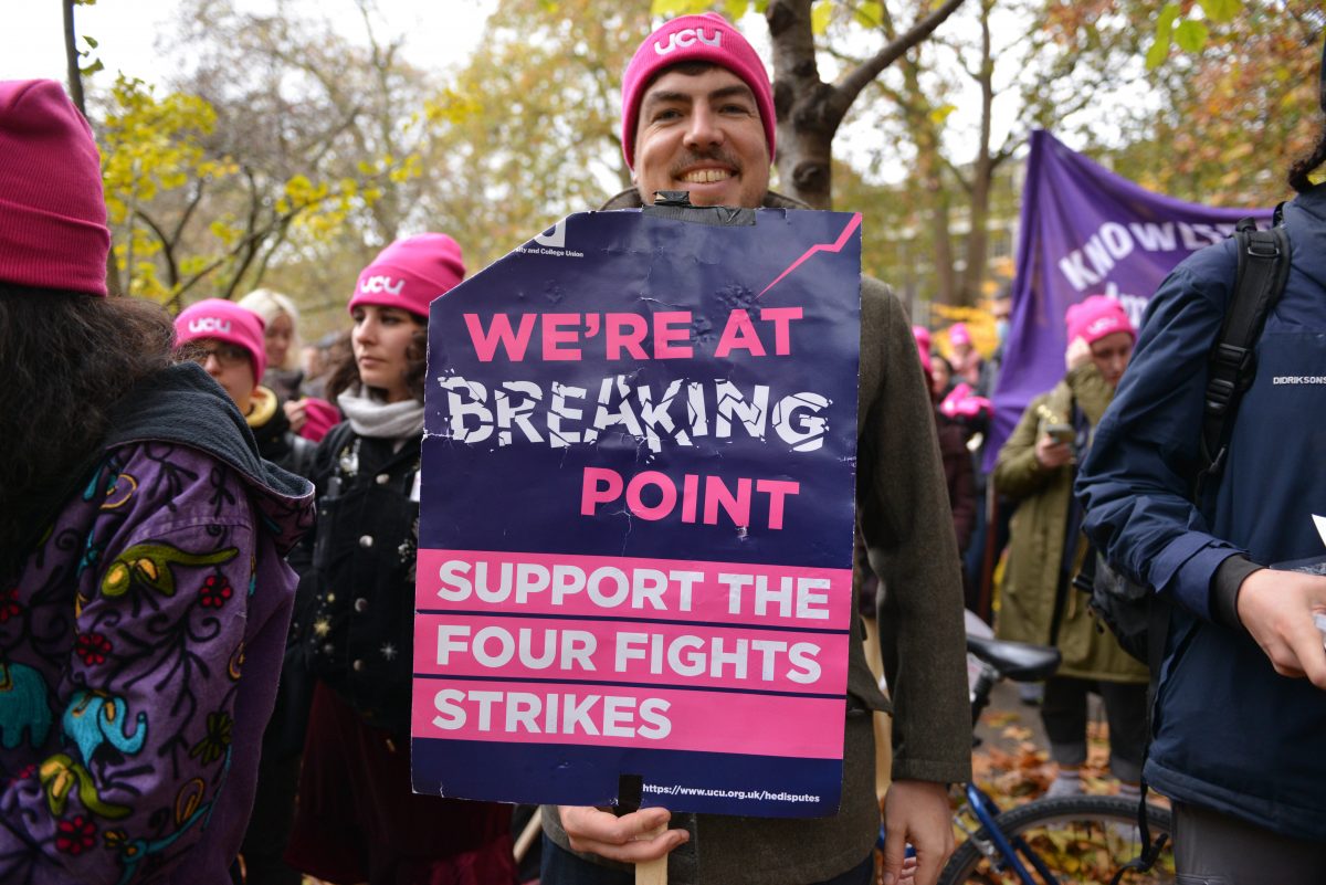 A person holding a sign reading 'we're at breaking point ; support the four fights strikes'