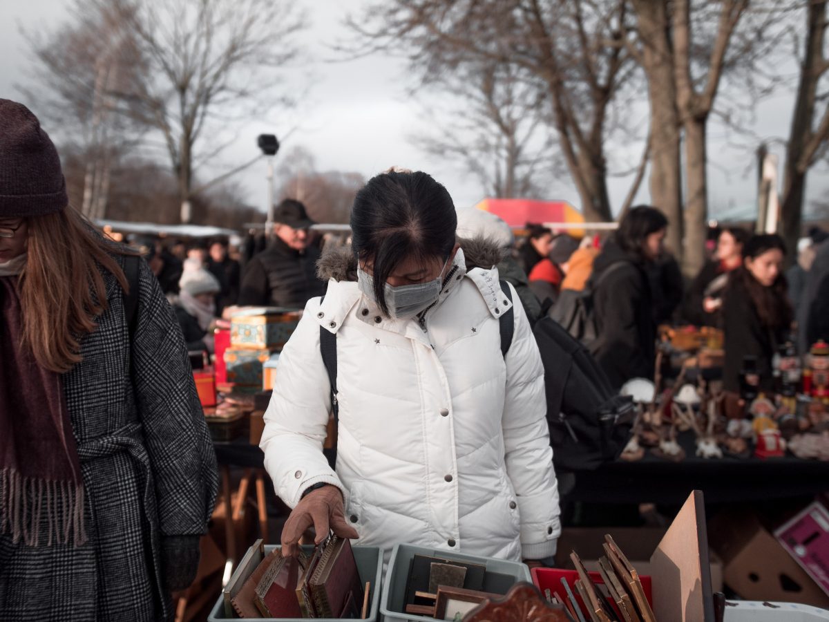 Person browsing postcards at a flea market 