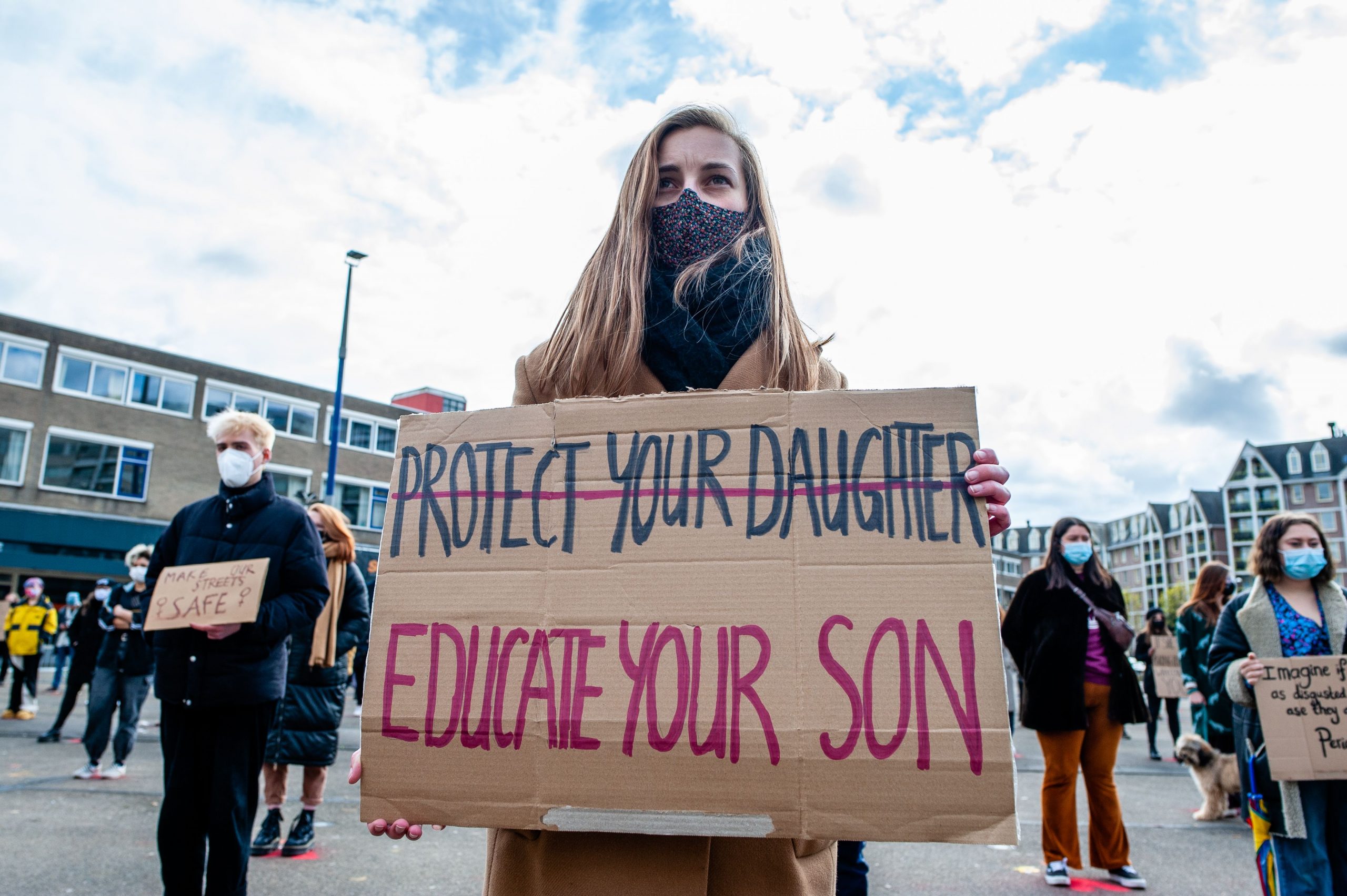 Protest sign reading"Educate your son" with "Protect your daughter" crossed out.