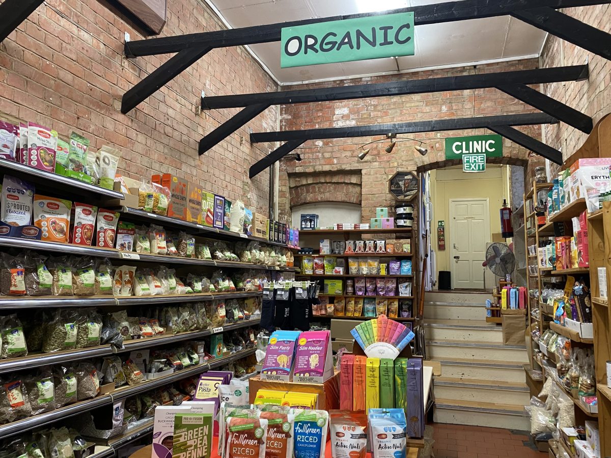 Tall shelves stacked with vegan treats against brick walls.