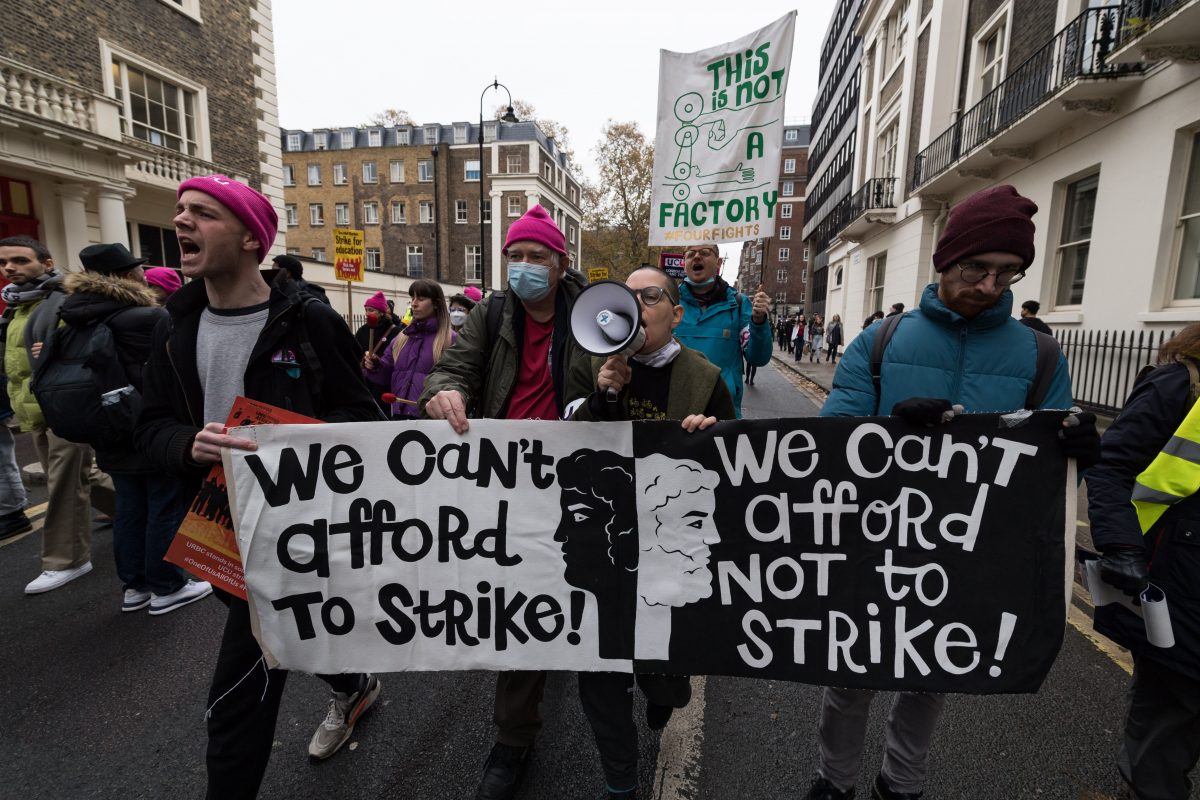 Protesters holding a banner reading: 'we cannot afford not to strike'