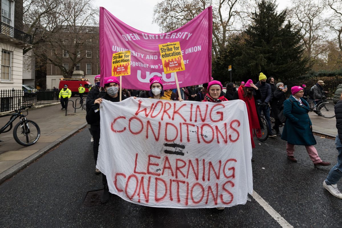 Protesters marching and holding a banner reading 'Working conditions = learning conditions"