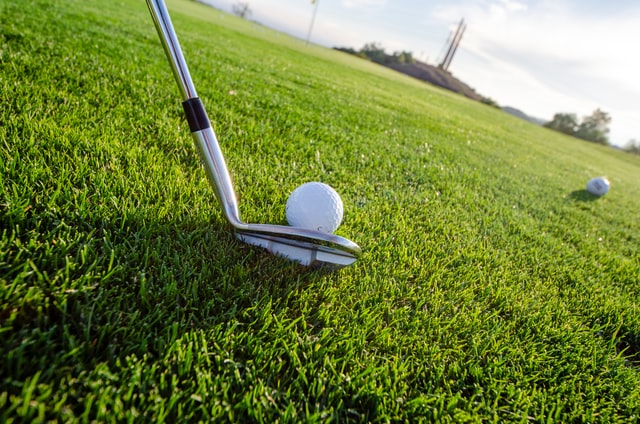 golf putt and ball in the grass