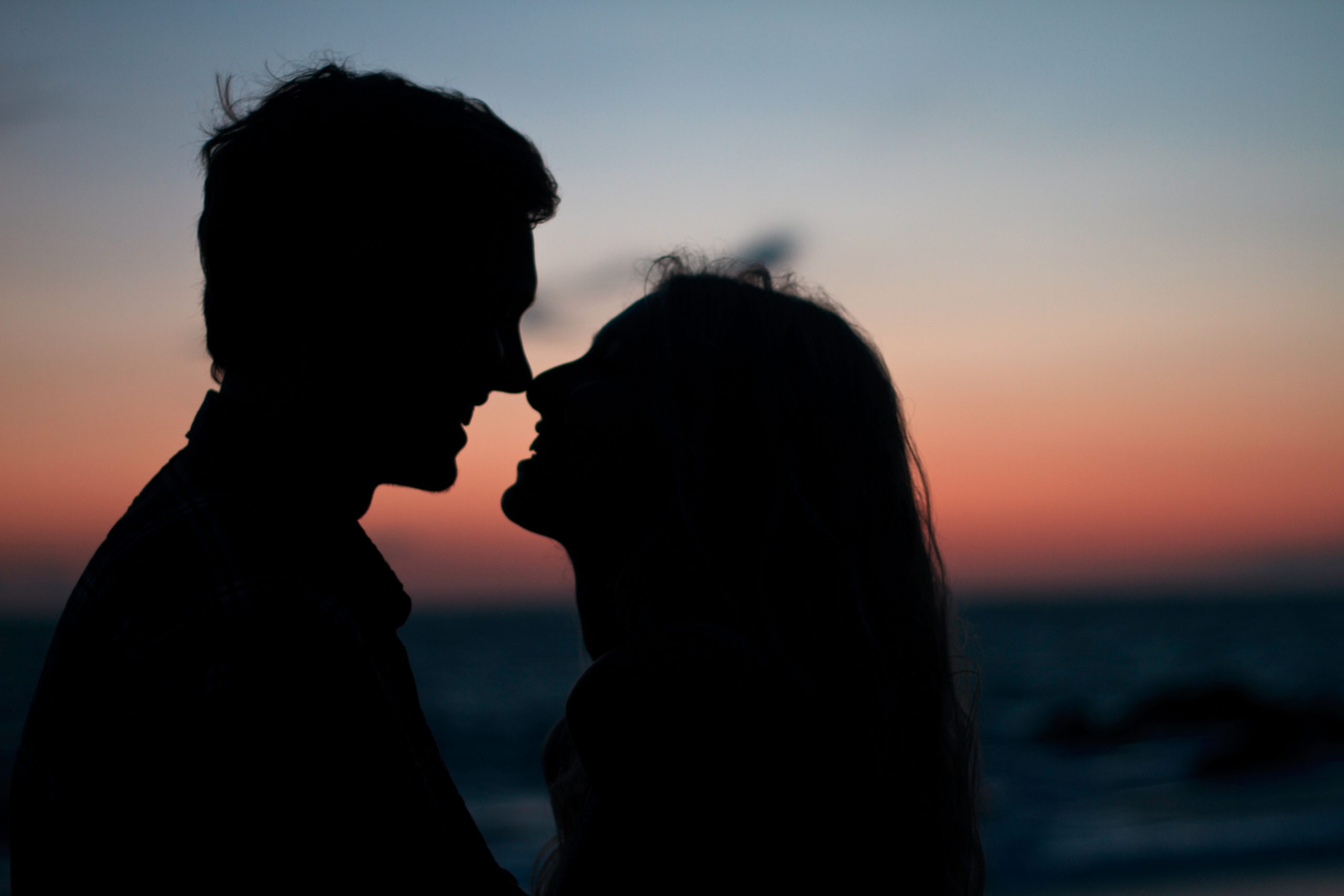 Silhouette of a couple in front of a sunset.