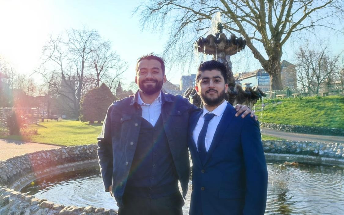 Khan and Samad posing together in a sunny park