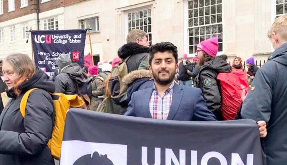 Sami Chaudhry holdin a Union of Kingston Students banner