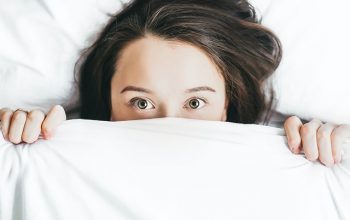 girl in bed under covers
