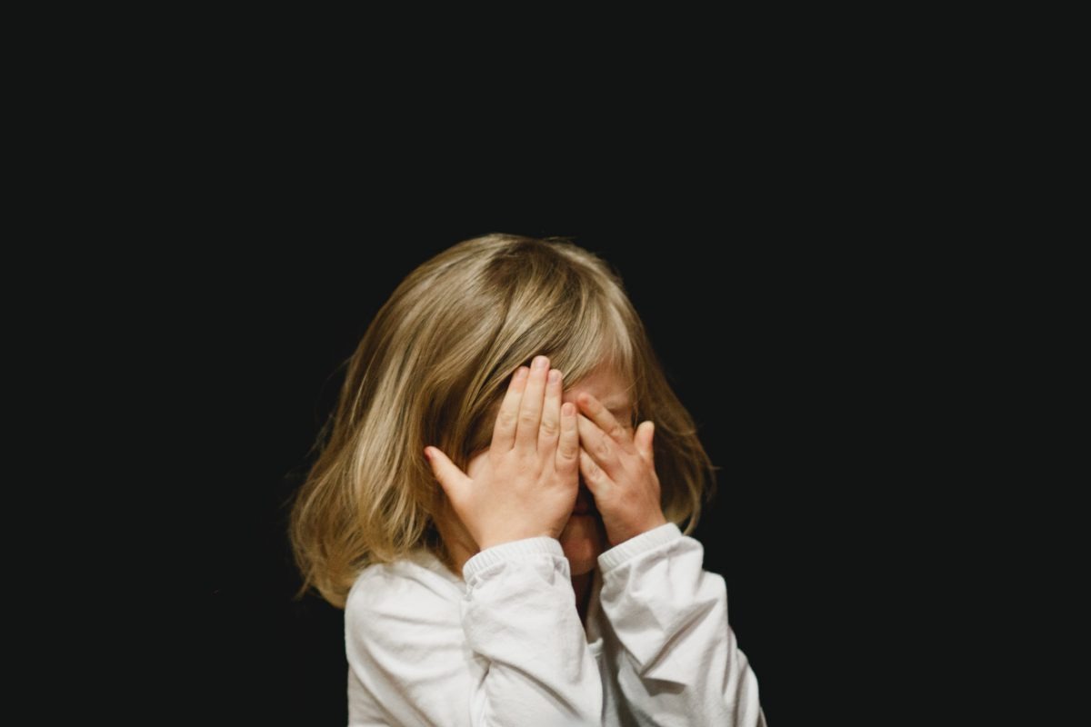 Young girl covering her face 