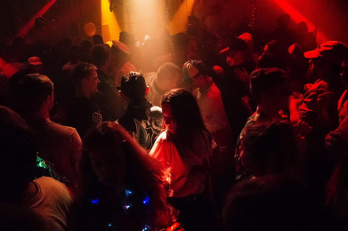 Crowd of people at an indoor party. 