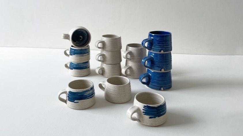 Multiple ceramic pottery designs of cups by Ellie Perrys