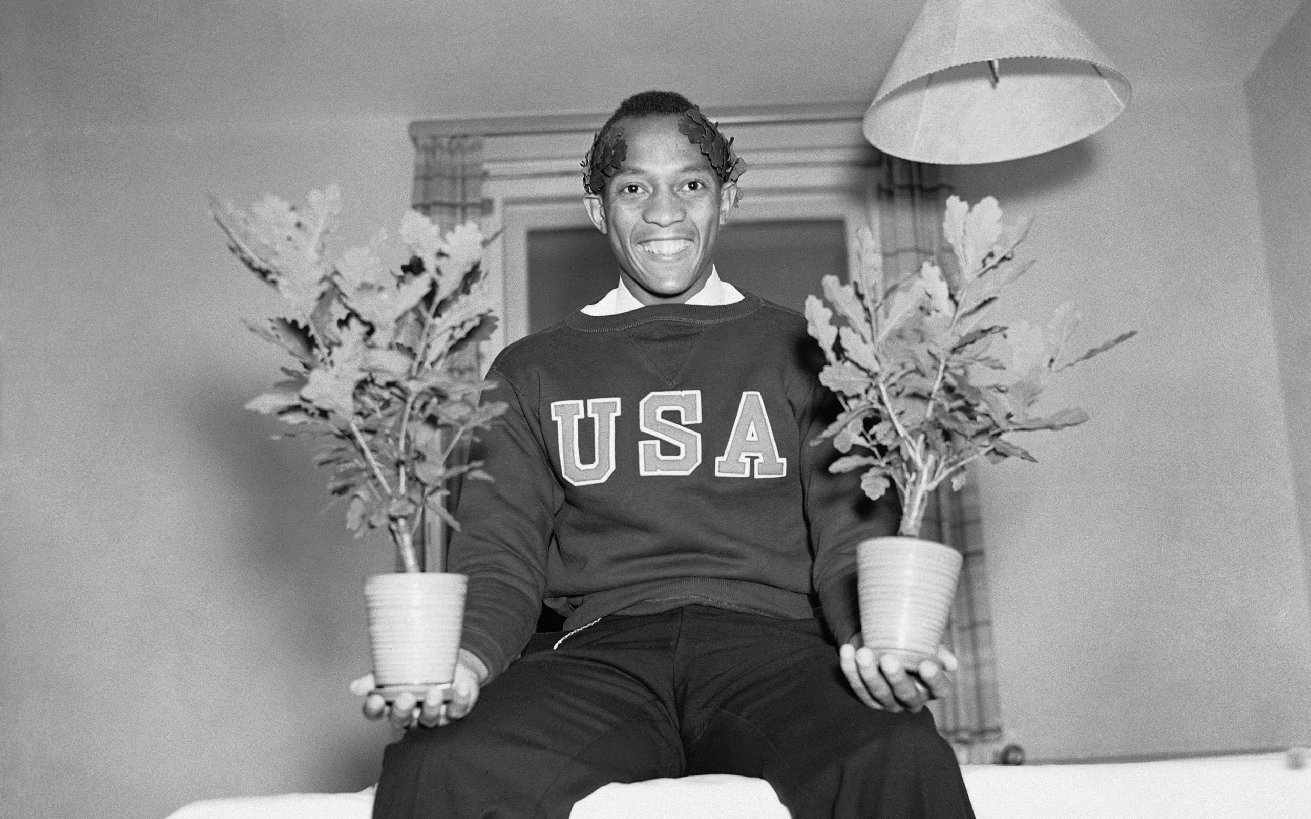 Jesse Owens is shown with two Olympic Oaks in Berlin, given to each winner.