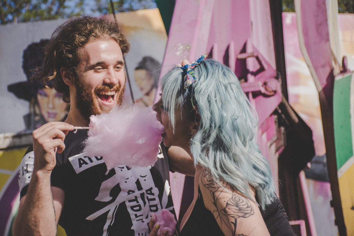 People eating cotton candy at a carnival