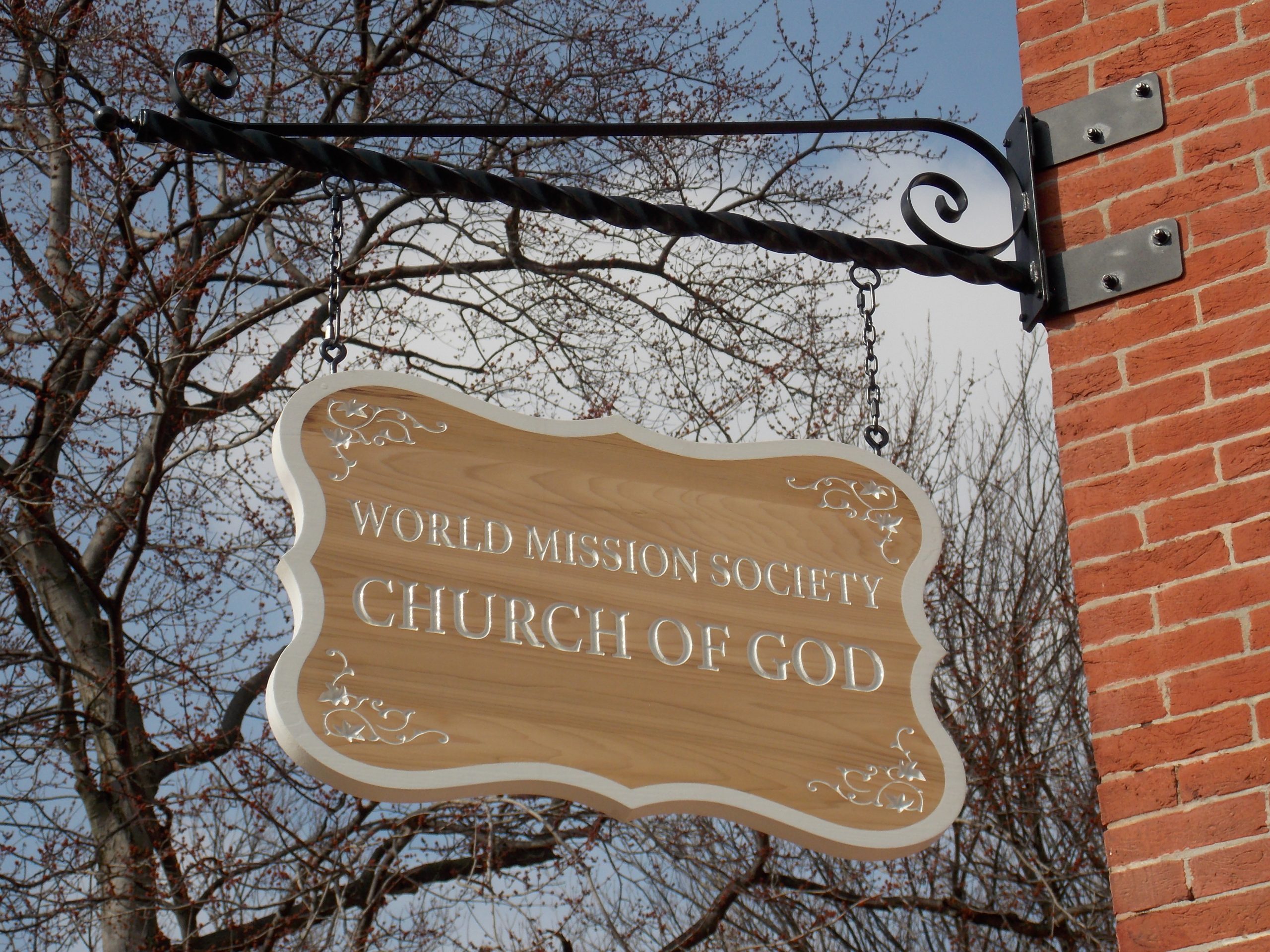 A sign for the World Mission Society Curch of God hanging on a building
