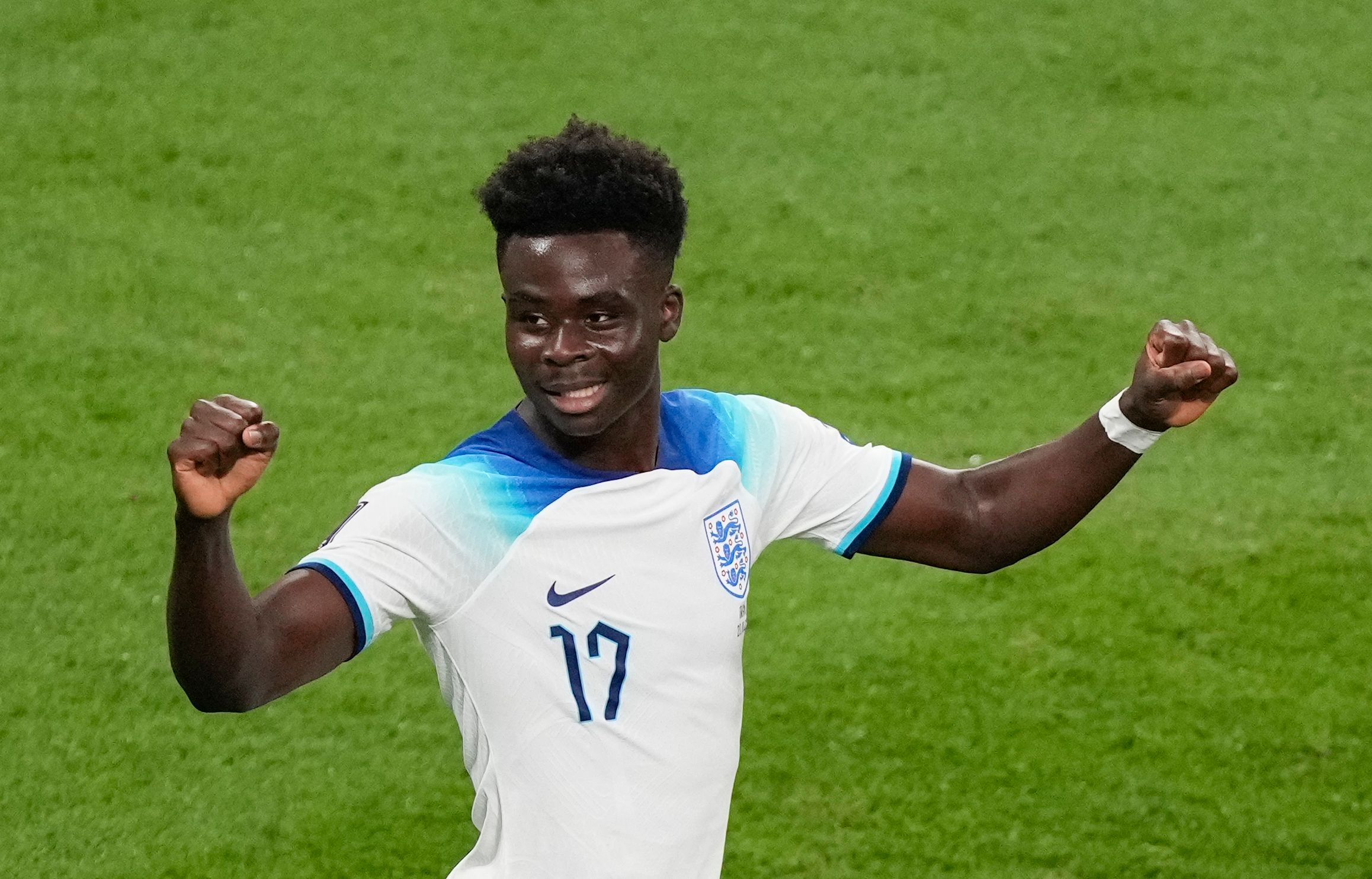 Saka with a smile on his face with both his fists balled up to celebrate England's fourth goal