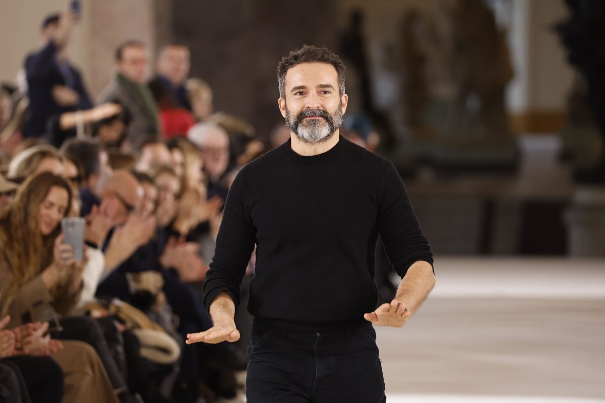 Creative director wearing black top on the runway