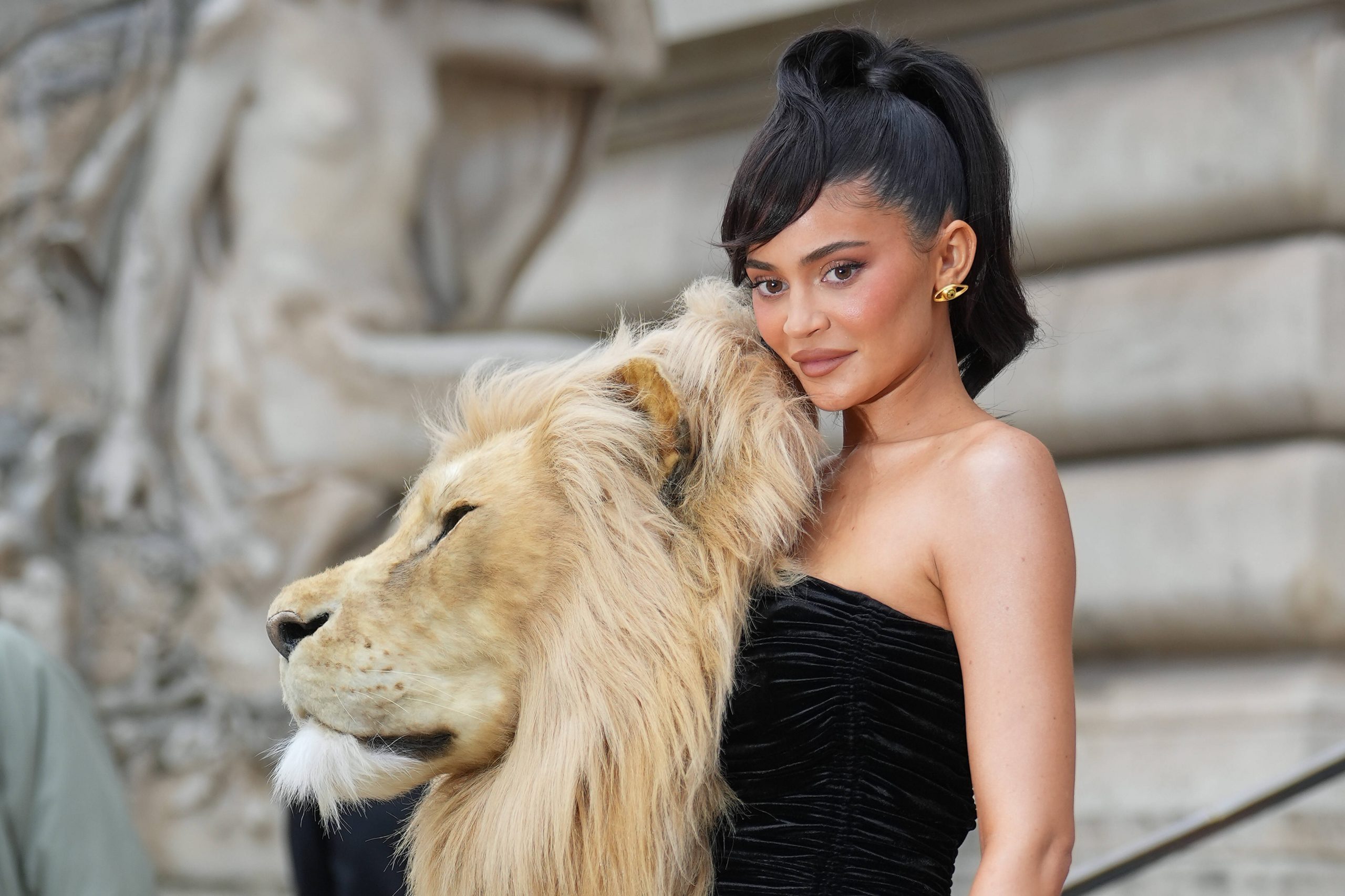 Kylie Jenner wearing a black dress with lions head