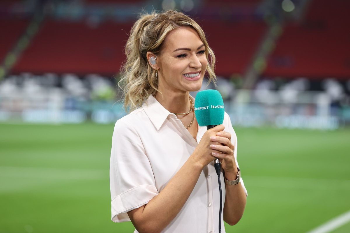 Laura smiling with her blond curly hair tied up and holding a microphone that says ITV Sport.