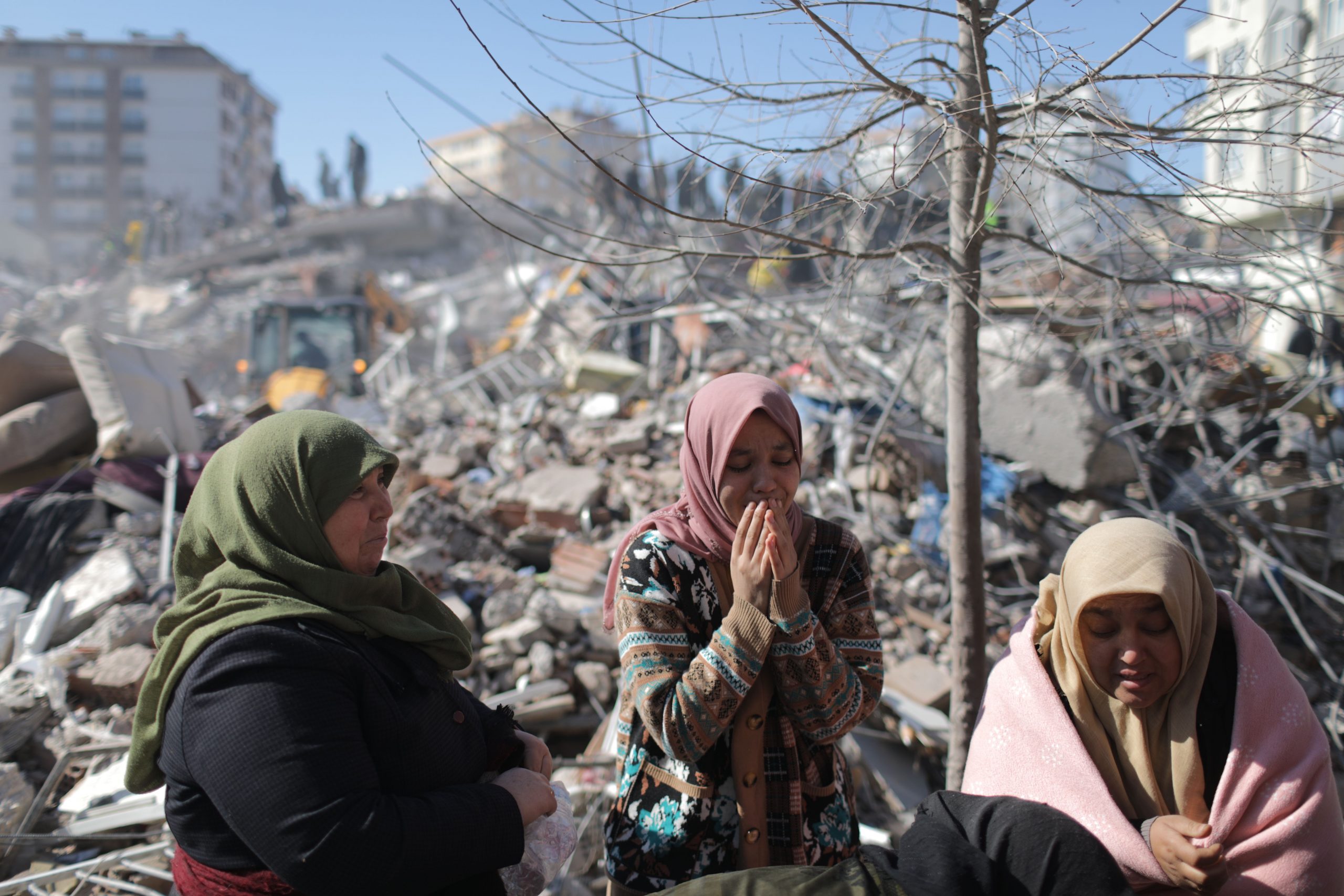 Three women crying over devastation caused