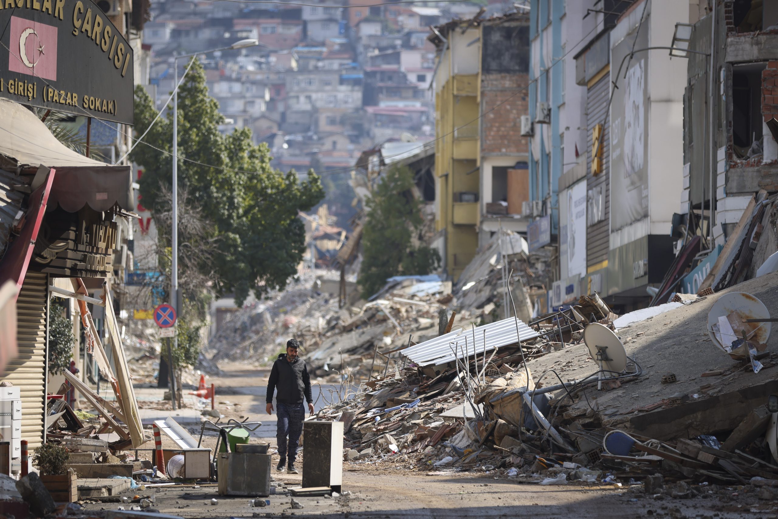 Man walks past destroyed buildings in Antakya, southeastern Turkey