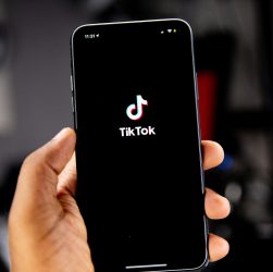 person holding a phonev with tiktok logo on screen