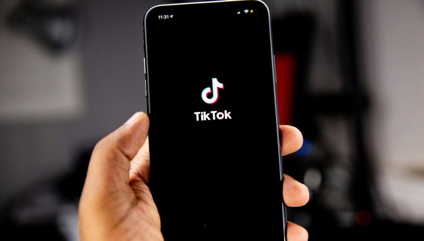 person holding a phonev with tiktok logo on screen